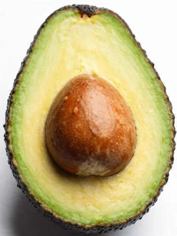 Avocat frais coupé montrant sa chair verte crémeuse, sur surface bois