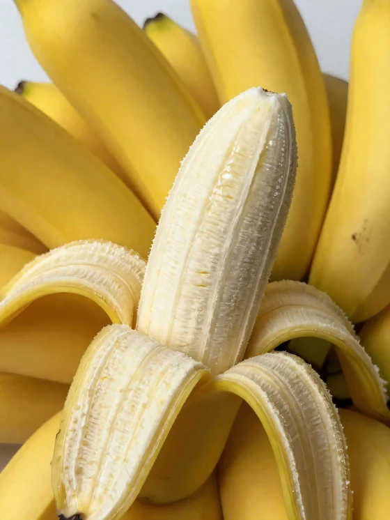 Banane fraîche entière et tranchée, dans un bol et sur table rustique