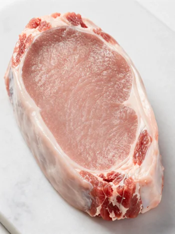 Morceaux de veau frais clair avec épices sur planche à découper en bois