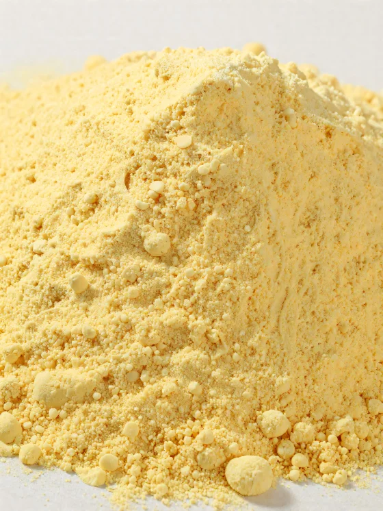 Farine de maïs jaune en poudre dans un bol en céramique sur bois