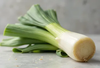 Poireaux frais entiers et en rondelles sur table en bois