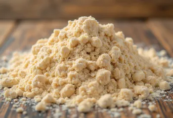 Bol de farine complète et grains de blé sur table en bois