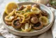 Champignons de Paris rôtis servis avec des poireaux, dorés, sur une assiette claire
