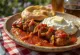 Iskender kebab sauce tomate épicée servi avec une sauce yaourt à l'ail et du pain pita grillé