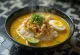 Bol de soupe jaune Soto Ayam avec riz, œuf et herbes