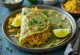 Pesarattu à l'upma, décoré de coriandre fraîche et citron vert, saveurs riches