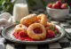Zeppole fourrés à la confiture de fraises, saupoudrés de sucre glace, servis sur un plat rustique