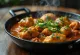 Karahi de poulet, riche en épices et yaourt, servi avec de la coriandre fraîche