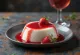 Panna cotta aux fraises décorée de fruits frais et de coulis