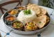Repas Thali avec divers plats comme riz basmati, curry de pois chiches, légumes, papadum et chutney de menthe