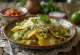 Chilaquiles verdes enrobés de sauce verte, servis avec crème fraîche et fromage râpé