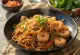 Yakisoba aux crevettes, mélange délicieux de nouilles et de légumes avec des crevettes et des graines de sésame