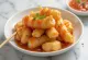 Cakwe servi avec une sauce épicée, parsemé de graines de sésame