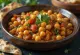 Tajine classique aux pois chiches, servi avec des légumes riches et herbes fraîches